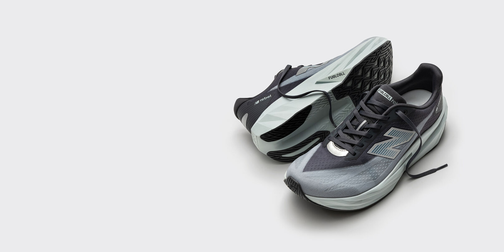 Mint and black running shoes on the ground and one is sideways